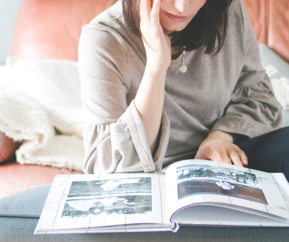 Image of woman looking at a digitally printed photo album of old family photos.