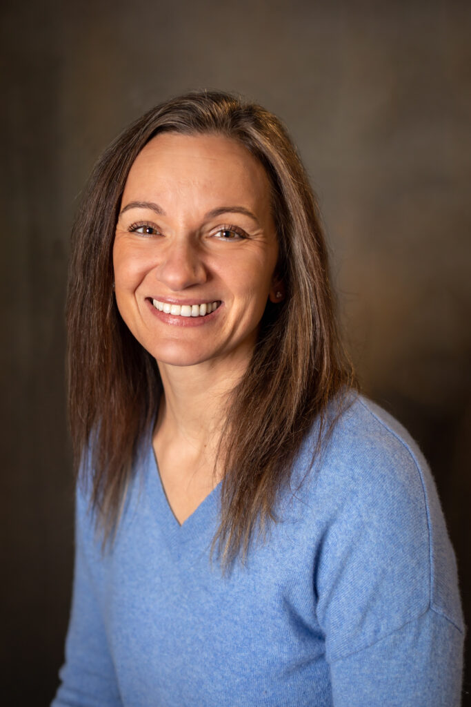 Headshot of Olimpia estate sale organizer with blue nest home.